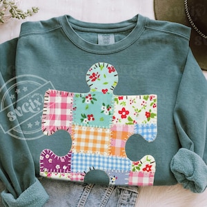 Puede incluir: Un juego de tres tazas de cerámica con un acabado mate moteado. Las tazas son de color crema, gris claro y gris oscuro. Cada taza tiene un diseño simple y moderno y un asa redondeada.