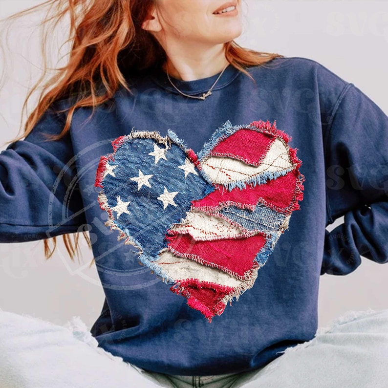 May include: A navy blue sweatshirt with a heart-shaped patch. The patch is made of denim and red fabric, with a design reminiscent of the American flag. The left side of the heart has white stars on blue denim, and the right side has red and white stripes.