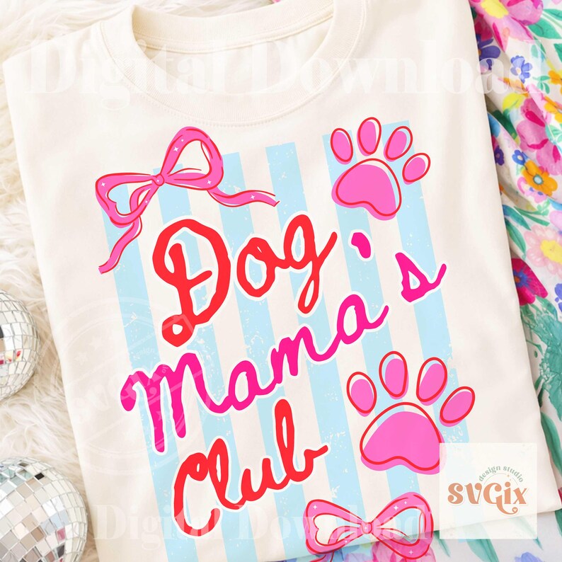 May include: Cream-colored t-shirt with the text "Dog's Mama Club" in red and pink script. The design includes pink paw prints, bows, and light blue vertical stripes. A fun and playful design for dog lovers.