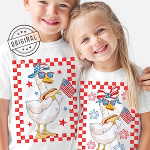 May include: Two white t-shirts with a red, white, and blue checkered background. Each shirt features a cartoon duck wearing sunglasses, a red, white, and blue bandana, and holding a hot dog. One duck is wearing a baseball cap and the other is wearing a red, white, and blue bow.