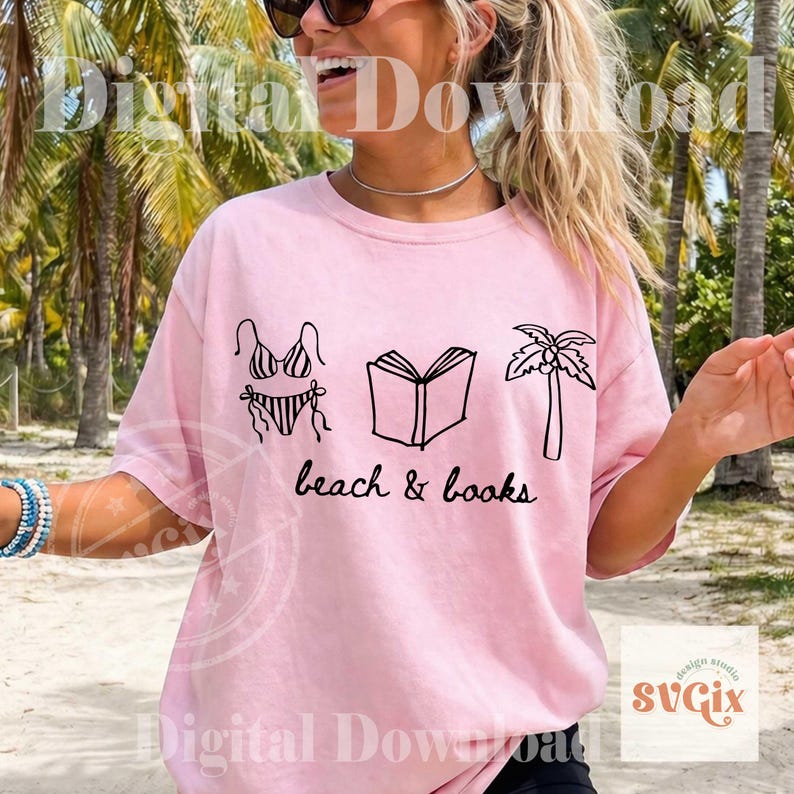 K&ouml;nnte beinhalten: Hellrosa T-Shirt mit schwarzer Grafik eines Bikinis, eines offenen Buches und einer Palme. Der Text "beach & books" steht darunter. Das T-Shirt hat einen l&auml;ssigen Stil.