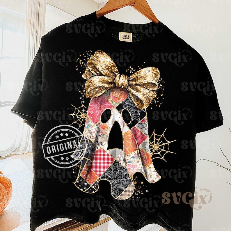Op de afbeelding: Zwart T-shirt met een patchwork spookontwerp en een gouden paillettenstrik. De geest heeft bloemen- en ruitpatronen. Op het shirt staat het woord "ORIGINAL".