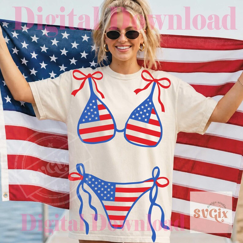 May include: Cream-colored t-shirt featuring a bikini design with the American flag. The bikini top has red bows, and the bottom has blue ties. The background includes an American flag.