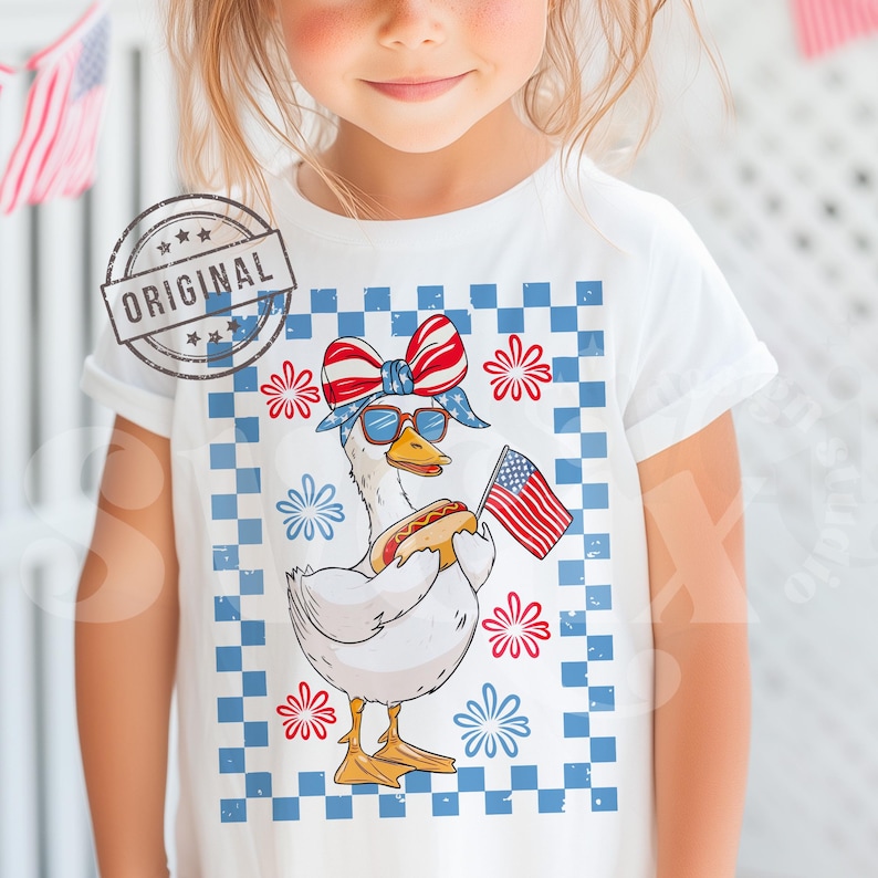 May include: A white t-shirt with a graphic of a goose wearing a red, white, and blue bandana and sunglasses, holding a hot dog and an American flag. The goose is standing on a blue and white checkered background with red, white, and blue flowers.