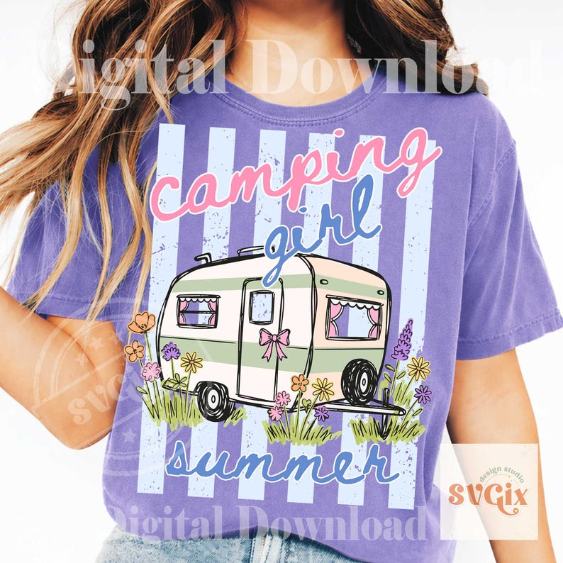 May include: A lilac t-shirt with a camping theme. The shirt features a camper illustration with the words "camping girl summer" in pink and blue script. The camper is surrounded by flowers and grass.