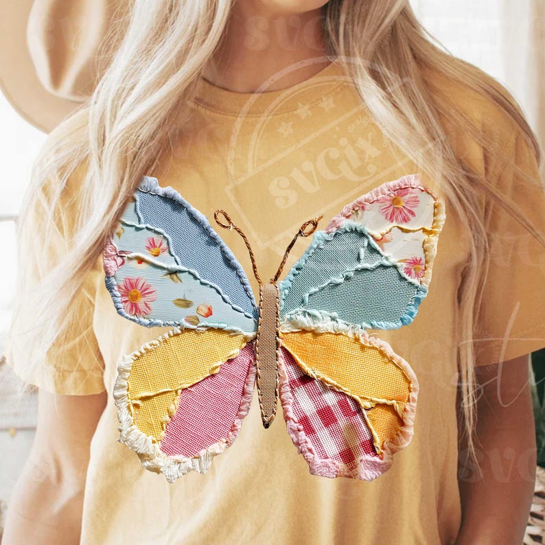 May include: Yellow t-shirt featuring a patchwork butterfly design. The butterfly has wings in various colors and patterns, including blue floral, yellow, pink gingham, and light blue. The butterfly's body is a tan color.