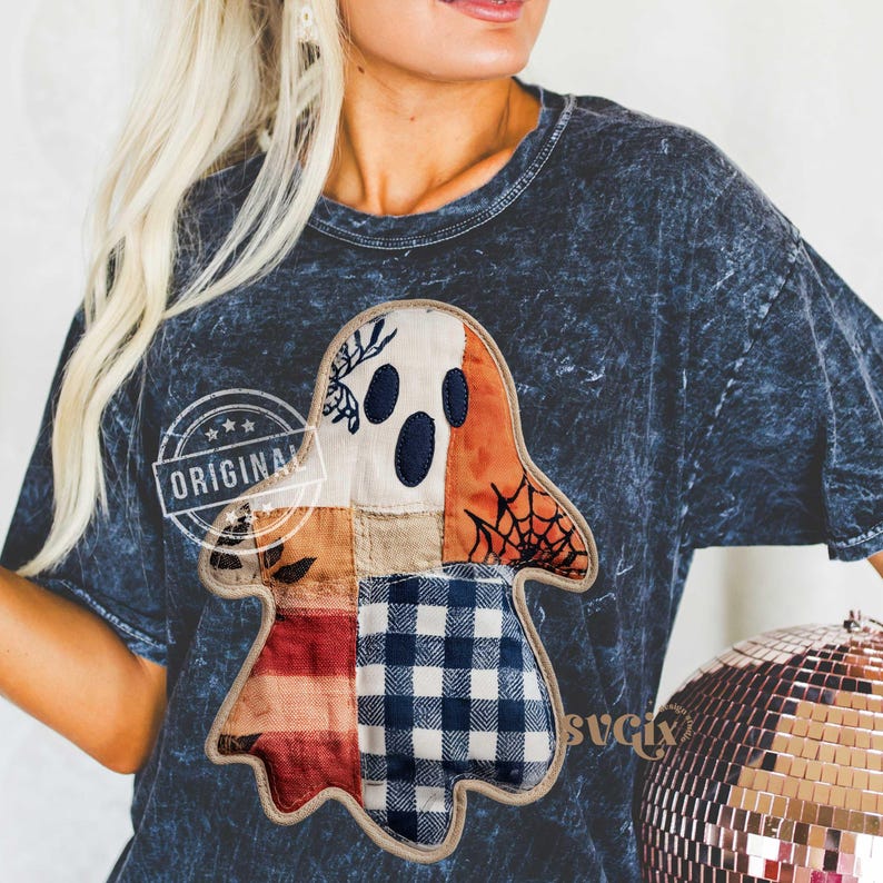 May include: Dark blue t-shirt with a patchwork ghost design. The ghost is made of various fabrics in cream, orange, and blue plaid. The shirt has a distressed look and the word "ORIGINAL" is printed on it.