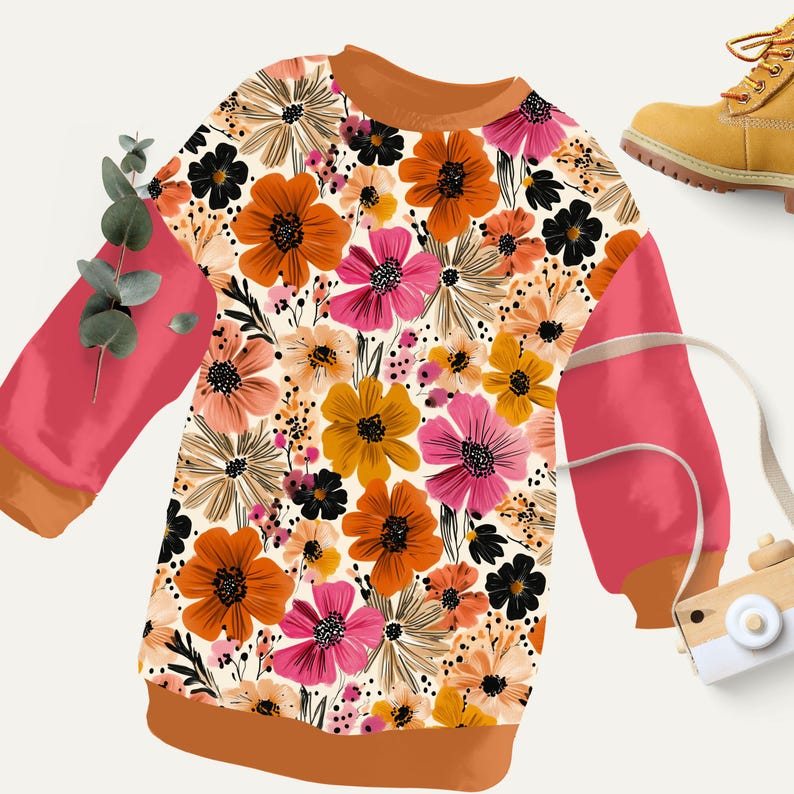 May include: A long-sleeved sweatshirt with a floral pattern in shades of orange, pink, black, and yellow. The sleeves are a solid coral color with brown trim. A yellow boot is in the upper right corner.