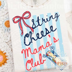 May include: Cream-coloured t-shirt with a graphic design featuring a red bow, blue and white striped background, and the words "String Cheese Mama's Club" in a playful font. A cartoon string cheese stick is also included.