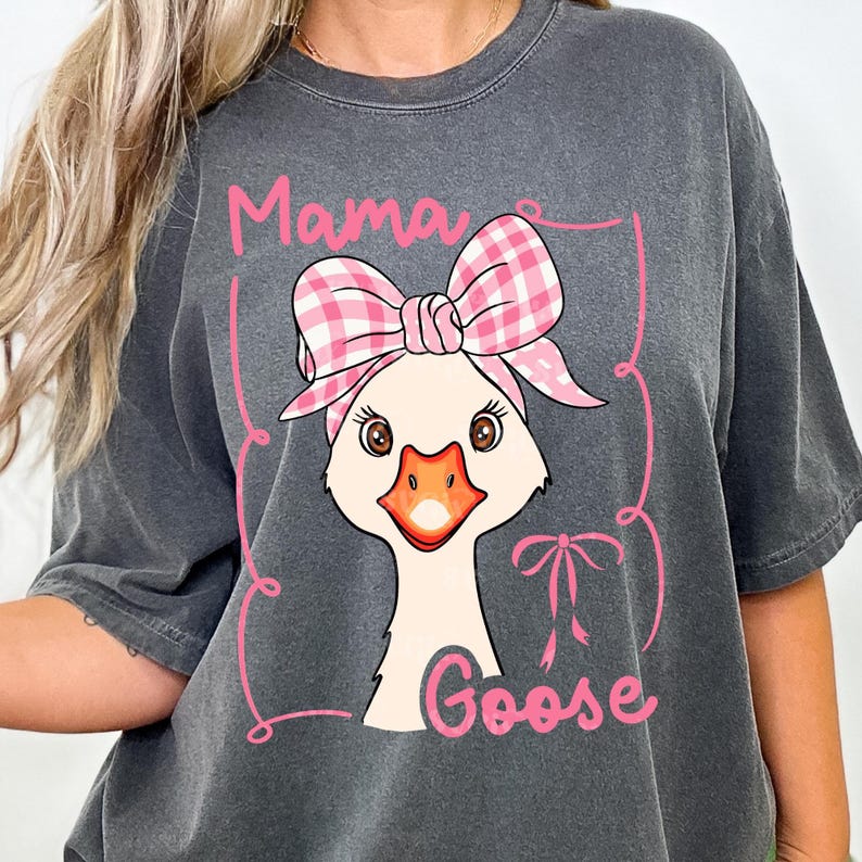 May include: A gray t-shirt with a pink and white gingham bow on a cartoon goose. The text "Mama Goose" is printed on the shirt.