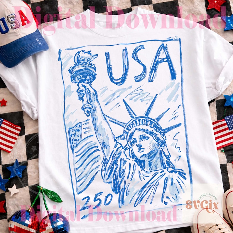 K&ouml;nnte beinhalten: Wei&szlig;es T-Shirt mit einer blauen Skizze der Freiheitsstatue, dem Wort "USA" und der Zahl "250". Eine wei&szlig;-blaue Baseballkappe mit "USA" ist ebenfalls zu sehen. Patriotisches Thema.