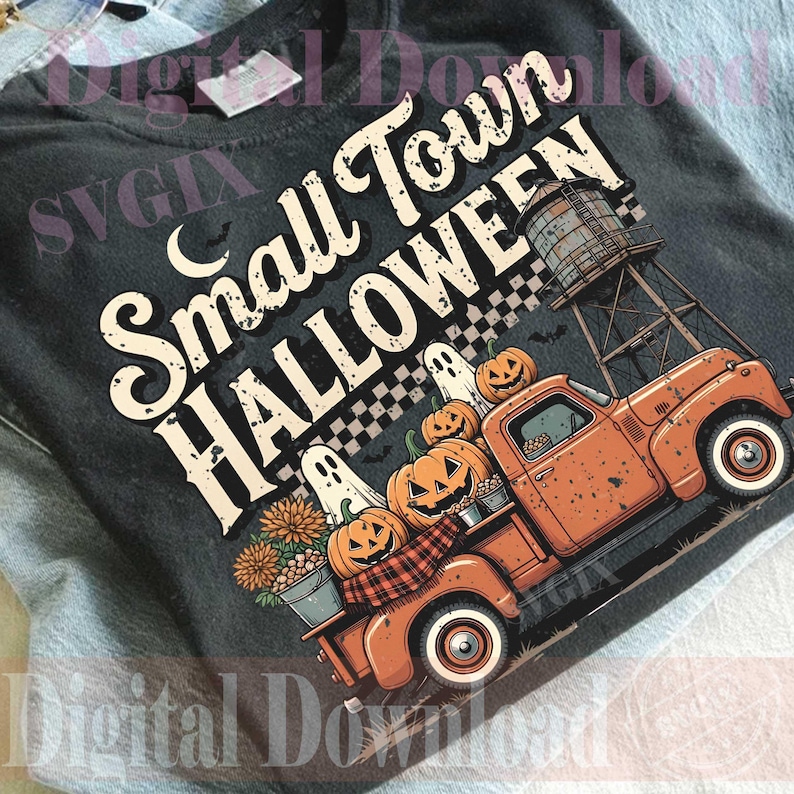 May include: A charcoal gray t-shirt featuring a graphic print with the text Small Town Halloween. The design includes an orange pickup truck, a water tower, pumpkins, ghosts, and flowers. The print has a distressed, vintage-inspired aesthetic.