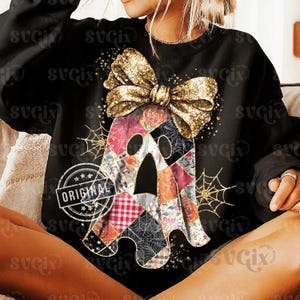Op de afbeelding: Zwart sweatshirt met een patchwork spookontwerp en een gouden glitterstrik. Het spook is gemaakt van verschillende stoffen met patronen, waaronder bloemen- en ruitjesprints. Gouden spinnenwebben en het woord "ORIGINAL" zijn ook zichtbaar.