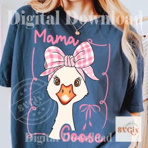 Pode incluir: Camiseta azul marinho com um desenho de ganso de desenho animado usando um la&ccedil;o e uma faixa xadrez rosa. O texto "Mama Goose" &eacute; exibido em rosa, junto com as palavras "Digital Download". O design inclui linhas rosas e um la&ccedil;o.