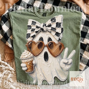 May include: An olive green t-shirt featuring a textured, impasto-style graphic of a white ghost wearing a black and white checkered bow, brown heart-shaped sunglasses, and holding a coffee cup while making a peace sign with one hand.