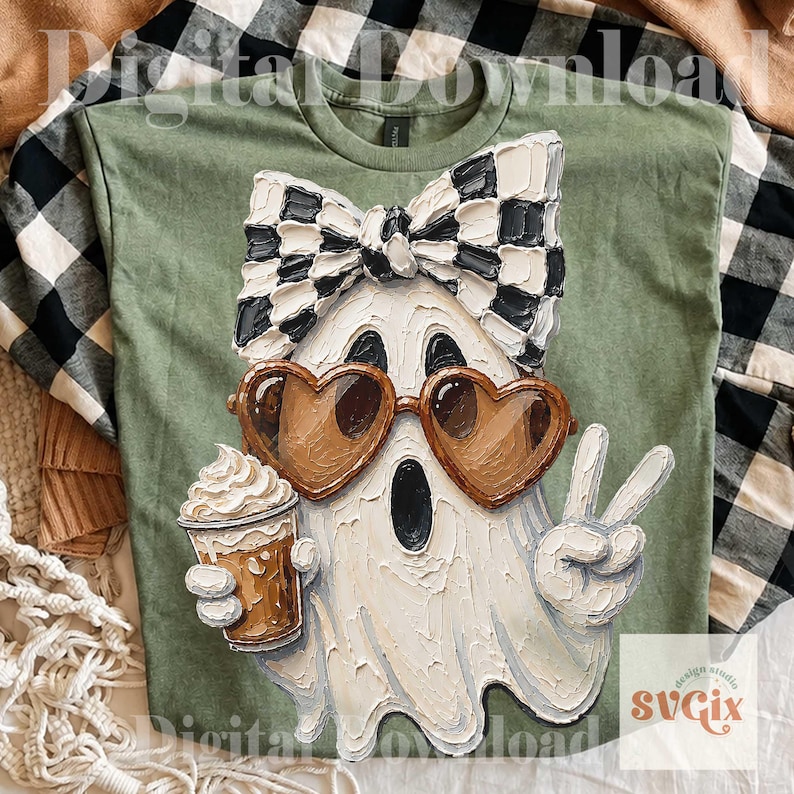 May include: An olive green t-shirt featuring a textured, impasto-style graphic of a white ghost wearing a black and white checkered bow, brown heart-shaped sunglasses, and holding a coffee cup while making a peace sign with one hand.