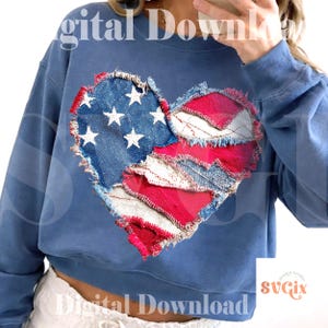 May include: A blue cropped sweatshirt featuring a heart-shaped design made from patches of denim and red fabric, resembling the American flag. The design includes white stars on a blue denim background and red and white stripes.
