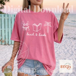 K&ouml;nnte beinhalten: Ein pinkfarbenes T-Shirt mit einer wei&szlig;en Grafik eines Bikinis, eines offenen Buches und einer Palme. Die Worte "beach & books" stehen darunter. Das Shirt ist ein digitaler Download.