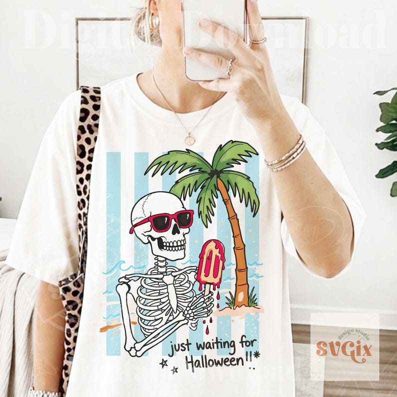 May include: White t-shirt featuring a skeleton wearing sunglasses and holding a melting popsicle. The skeleton is on a beach with a palm tree and the text "just waiting for Halloween!!*". The design has blue and white stripes in the background.