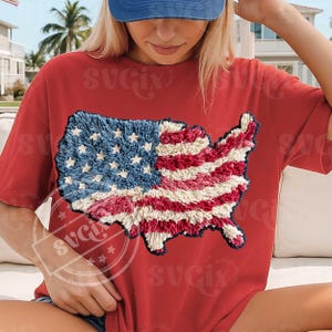 Peut inclure: T-shirt rouge avec un motif texturé du drapeau des États-Unis. Le motif du drapeau incorpore des éléments bleus, blancs et rouges, avec des étoiles et des rayures. Le t-shirt est de style décontracté, adapté aux événements patriotiques.