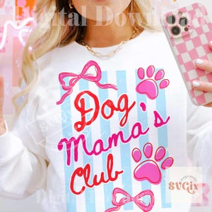 May include: White sweatshirt with the text "Dog Mama Club" in red and pink script, accented with pink paw prints and bows. The design features light blue vertical stripes. A pink and white checkered phone case is visible.