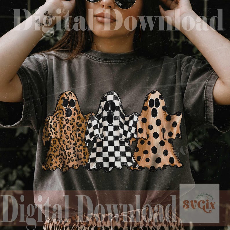 May include: A charcoal gray short-sleeve t-shirt featuring a graphic of three ghosts. The left ghost has a brown leopard print, the center ghost has a black and white checkerboard pattern, and the right ghost has a brown polka dot pattern.
