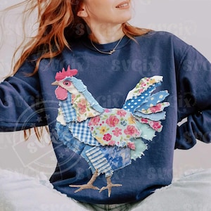 May include: Navy blue sweatshirt featuring a patchwork rooster design. The rooster is made of various patterned fabrics, including floral, gingham, and striped patterns in shades of blue, pink, and white. The rooster has a red comb and wattle.