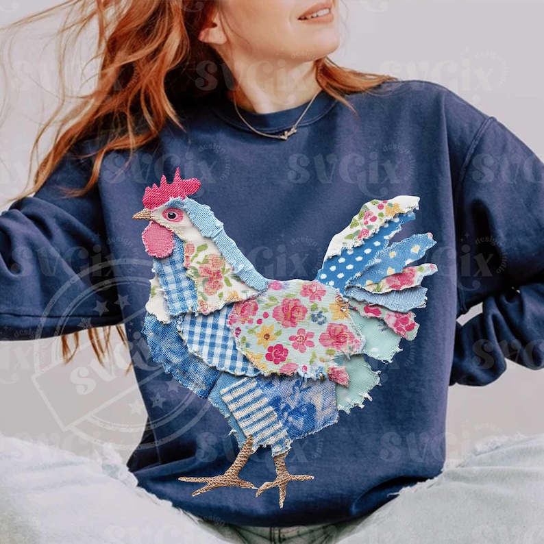 May include: Navy blue sweatshirt featuring a patchwork rooster design. The rooster is made of various patterned fabrics, including floral, gingham, and striped patterns in shades of blue, pink, and white. The rooster has a red comb and wattle.