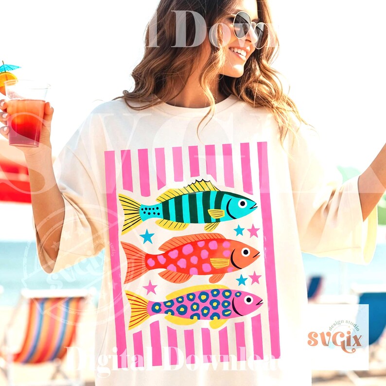 May include: Cream-colored t-shirt featuring a vibrant graphic of three colorful fish with pink vertical stripes. The fish are blue, orange, and pink, with star accents. The shirt is a digital download.