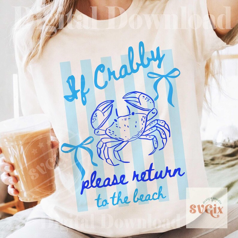 May include: Cream-colored t-shirt with a blue crab illustration and the text "If Crabby please return to the beach." The design includes blue vertical stripes and bows, perfect for a beach or summer theme.