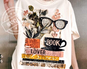 May include: Cream-colored t-shirt featuring a collage design with the word "BOOK" and a coffee cup. The design includes eyeglasses, flowers, and the word "LOVER" on a stack of books. The shirt has short sleeves.