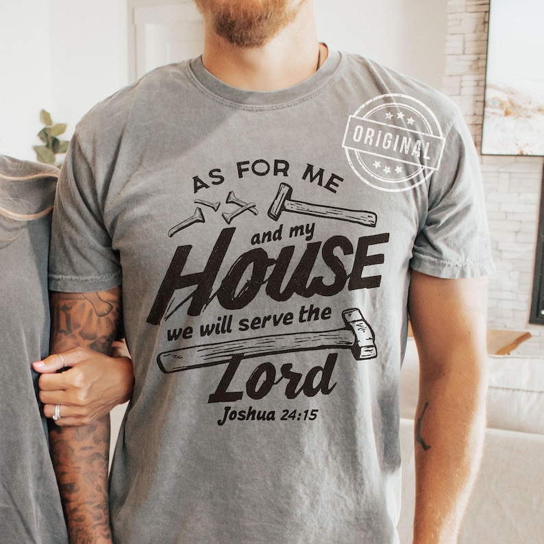 May include: Gray t-shirt with the text "AS FOR ME and my HOUSE we will serve the Lord Joshua 24:15" in black. The design includes illustrations of a hammer and nails. The shirt has a vintage look.