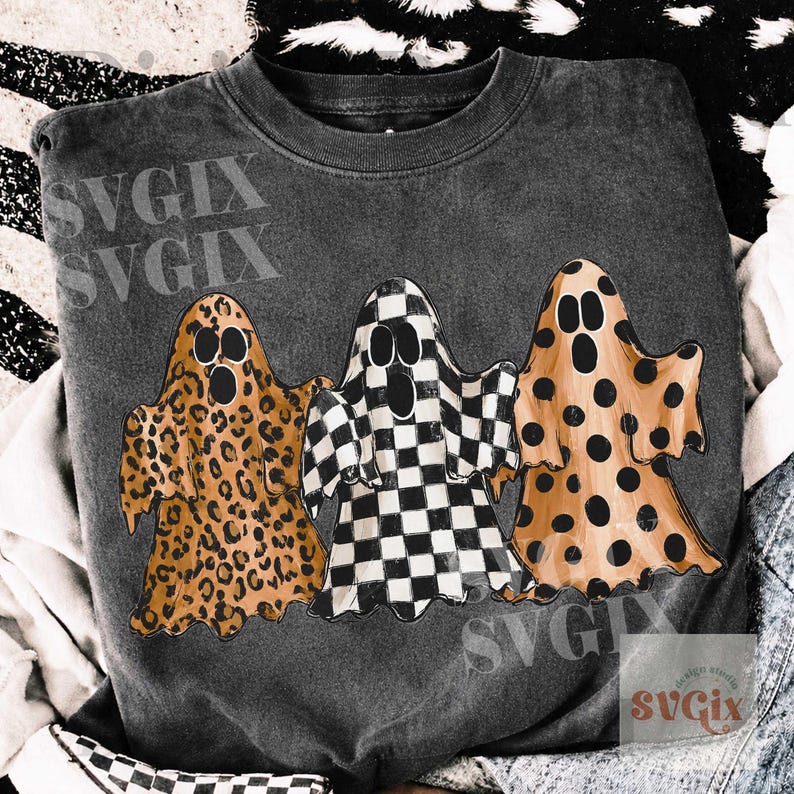 May include: Dark gray sweatshirt featuring three cartoon ghosts with unique patterns. One ghost has a leopard print, another a black and white checkerboard, and the third has orange polka dots. The design is centered on the shirt.