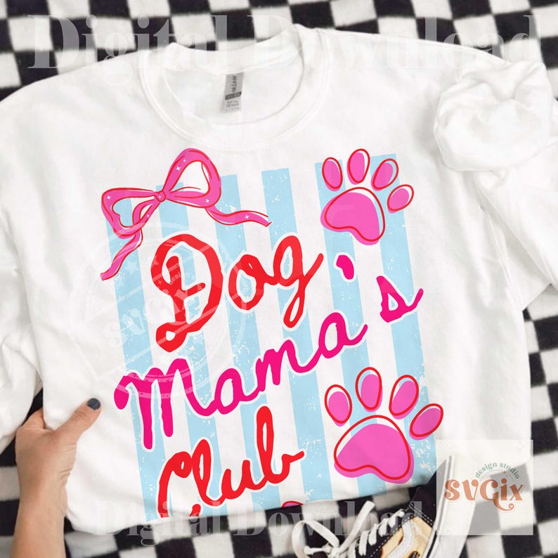 May include: White sweatshirt with the text "Dog Mama's Club" in red and pink script, accented with a pink bow and paw prints. The design features light blue vertical stripes. A casual, comfortable top for dog lovers.