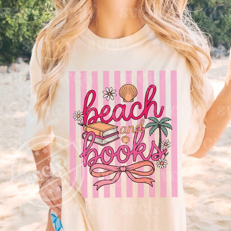 Puede incluir: Camiseta color crema con dise&ntilde;o de rayas rosas y blancas. El gr&aacute;fico muestra las palabras "beach and books" en cursiva, con ilustraciones de conchas marinas, flores, libros y una palmera. Un lazo en la parte inferior.