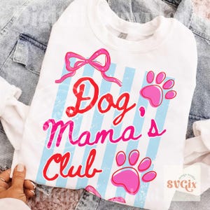 May include: White sweatshirt with the text "Dog Mama's Club" in red and pink, with a pink bow and paw prints. The design features light blue vertical stripes. The sweatshirt is displayed on a denim jacket.
