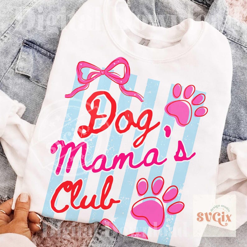 May include: White sweatshirt with the text "Dog Mama's Club" in red and pink, with a pink bow and paw prints. The design features light blue vertical stripes. The sweatshirt is displayed on a denim jacket.