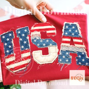 May include: A red fabric with the letters "USA" appliquéd on it. The letters are made of denim and red and white striped fabric, with white stars and lace accents. The design is patriotic.