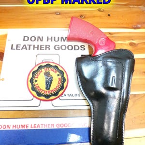 May include: A white ceramic mug with a black handle and the text "But First, Coffee" in a black, bold font. The mug is on a white surface.