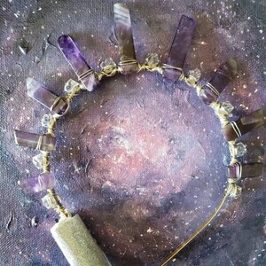May include: A gold wire headband with amethyst crystals and clear beads. The headband is bent into a semi-circle shape.