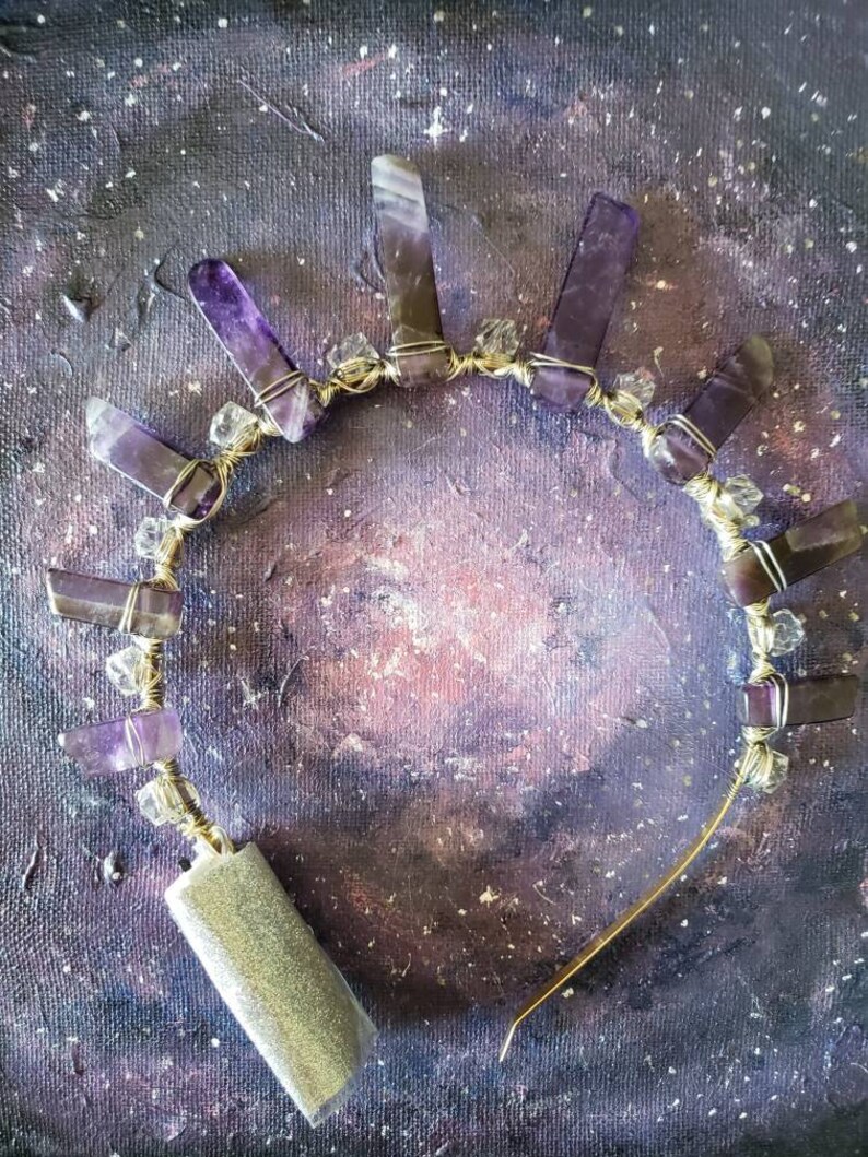May include: A gold wire headband with amethyst crystals and clear beads. The headband is bent into a semi-circle shape.