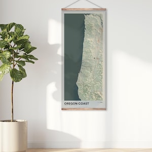 May include: A vertical map print of the Oregon Coast with a wooden frame. The map is a topographic map with green and blue colors. The text "OREGON COAST" is printed at the bottom of the map.