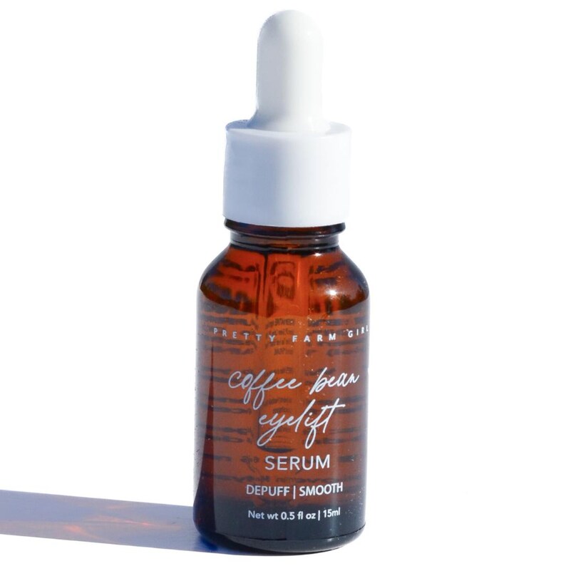 May include: A brown glass bottle with a white dropper top. The bottle contains a serum called "Coffee Bean Eyelift" with the text "Serum, Depuff | Smooth, Net wt 0.5 fl oz | 15ml".