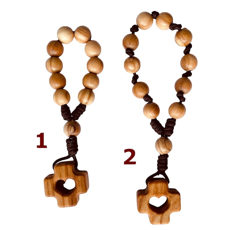 May include: Two wooden rosaries with brown cords and heart-shaped cross charms. The rosaries are made of small, round beads.