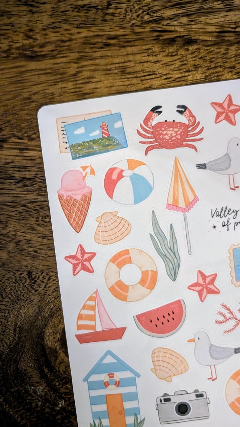Może przedstawiać: Kolekcja kolorowych naklejek o tematyce letniej z r&oacute;żnymi ilustracjami. Naklejki zawierają kraba, lody, piłkę plażową, muszlę, żagl&oacute;wkę, plaster arbuza i aparat fotograficzny. Naklejki są na białym tle.