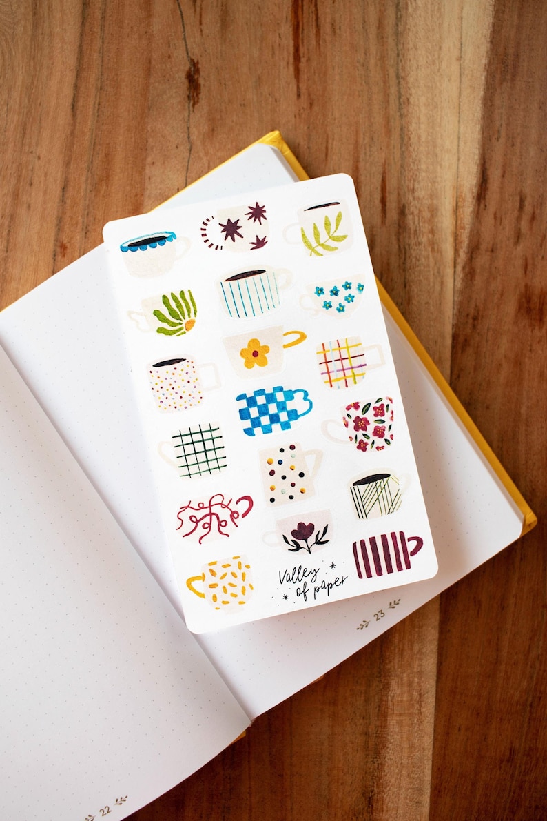 May include: A sheet of stickers featuring various colorful mugs with different patterns. The stickers are on a white background and have the text "Valley of paper" in the bottom right corner.