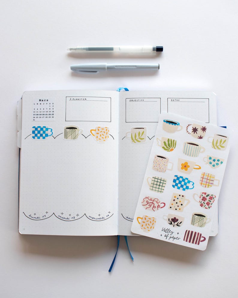 May include: A sheet of stickers featuring various colorful mugs with different patterns. The stickers are arranged in rows and columns on a white background. The text "Valley of Paper" is printed in the bottom right corner of the sheet.