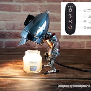 May include: A steampunk-style table lamp with a chrome lampshade and copper accents. The lamp is illuminating a candle jar. The lamp has a remote control with a timer, plus and minus buttons, and an on/off switch. The remote control is labeled with the functions of each button. The lamp is designed by Robolight2018.