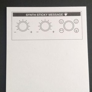 Peut inclure: Une image en noir et blanc d'une feuille de papier blanche avec le texte "SYNTH STICKY MESSAGE" en haut. Le papier comporte deux boutons avec des signes plus et moins, et quatre icônes : un visage triste, un visage joyeux, deux x et un cercle avec un point au centre.