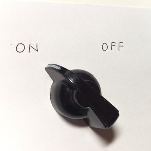 May include: Black plastic knob with a white line on the top. The knob is labelled "ON" and "OFF" on either side.